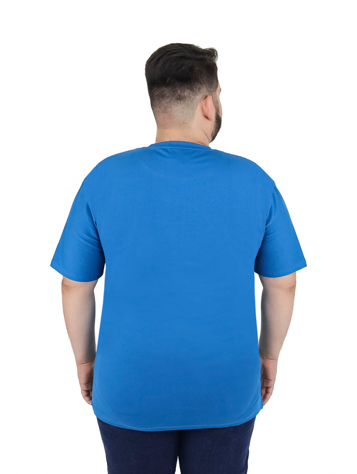 Hombre vistiendo una playera de manga corta color azul aqua de corte amplio.