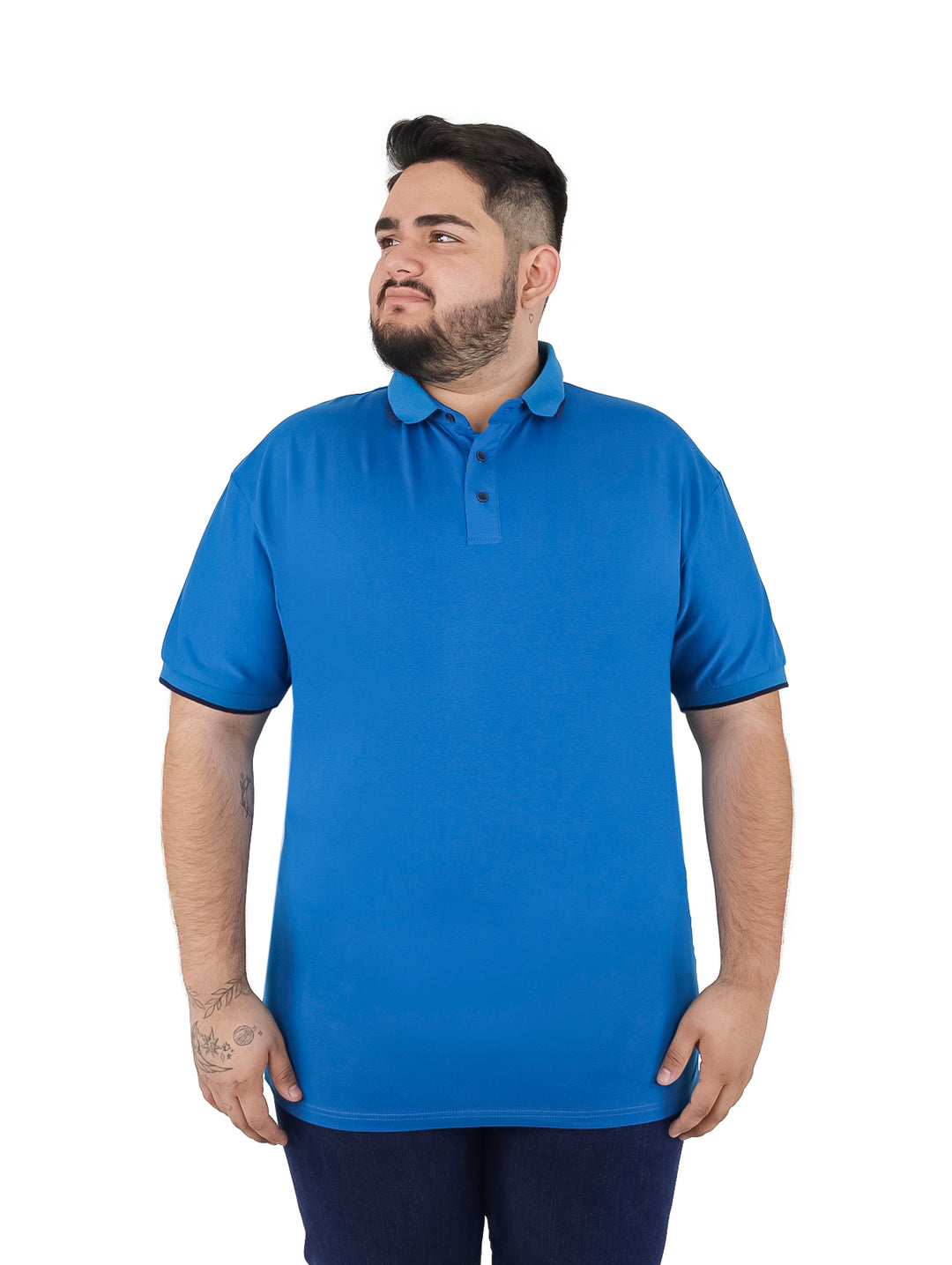 Hombre vistiendo una playera polo color azul con detalles en azul marino en el cuello y mangas.