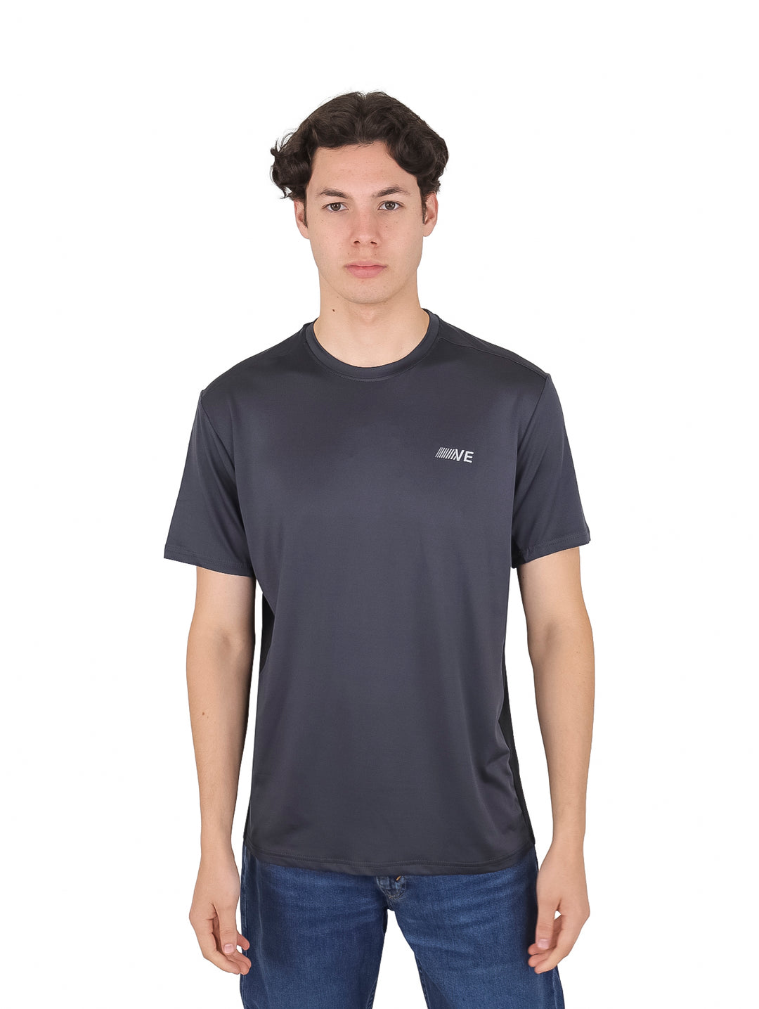 Hombre vistiendo una playera de manga corta color gris oscuro con un pequeño logotipo en el pecho.