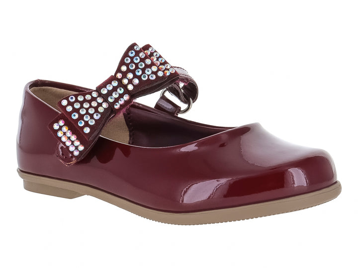 Zapato plano de charol color vino para niña con moño decorado con pedrería brillante y suela beige.