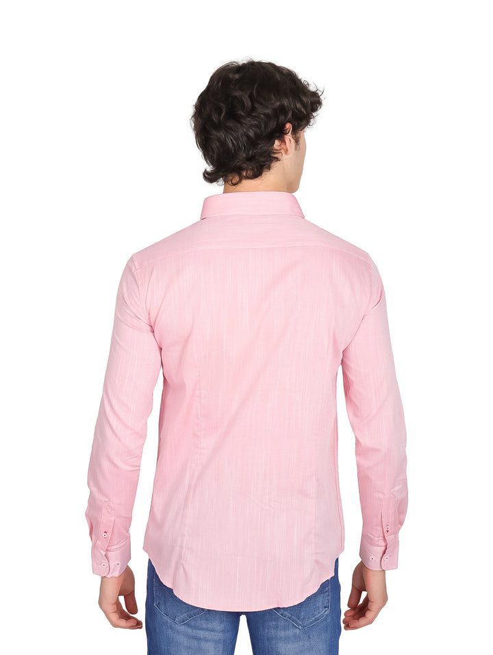 Hombre vistiendo una camisa de color rosa fresa con detalles rojos en el cuello y pantalones jeans azules.