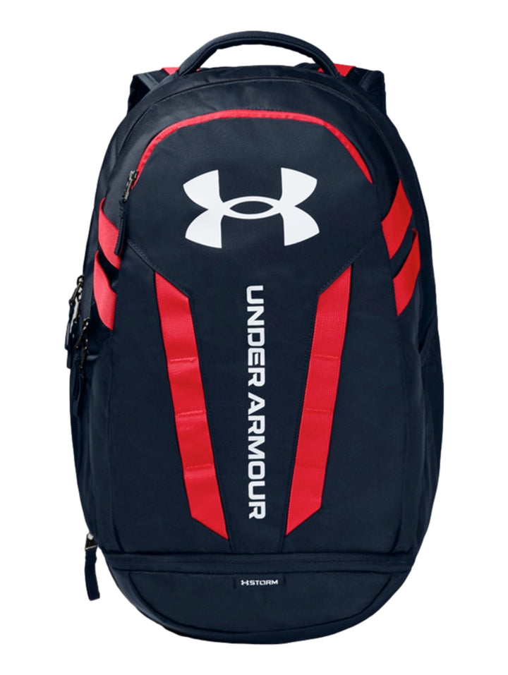 Mochila Under Armour Hustle 5.0 en color azul marino con detalles decorativos en rojo y logotipo blanco frontal.