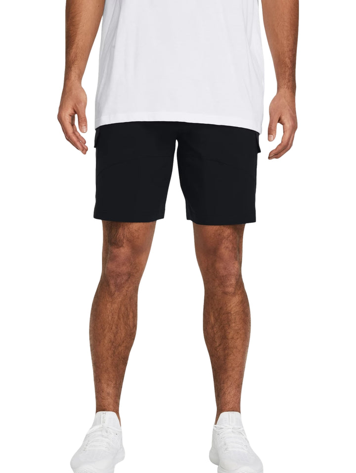Hombre vistiendo shorts deportivos cargo de color negro marca Under Armour con camiseta blanca y tenis blancos.