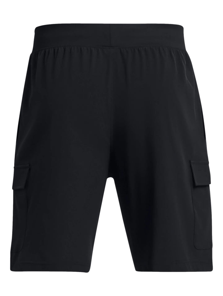 Hombre vistiendo shorts deportivos cargo de color negro marca Under Armour con camiseta blanca y tenis blancos.