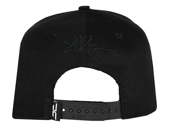 Gorra snapback color negro con un parche frontal detallado de la cabeza de un león con corona en tonos negros y grises.