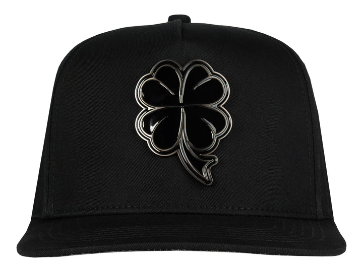 Gorra snapback color negro con un logo de trébol brillante en el frente.
