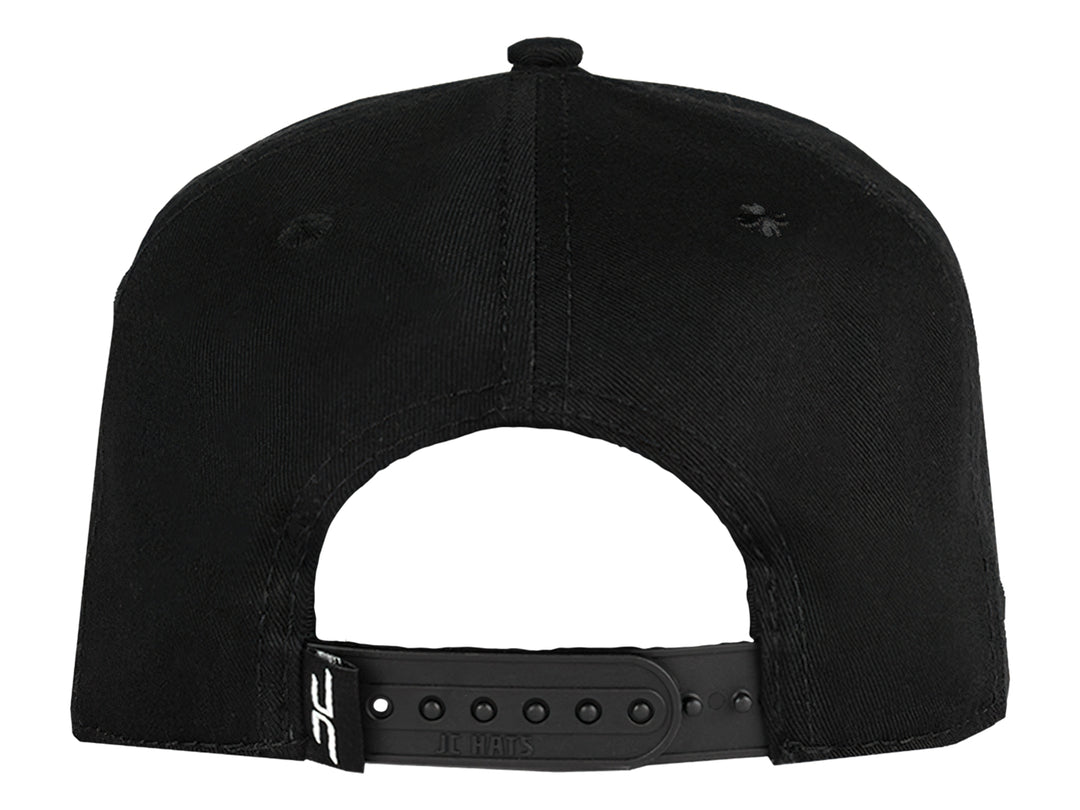 Gorra snapback color negro con un logo de trébol brillante en el frente.