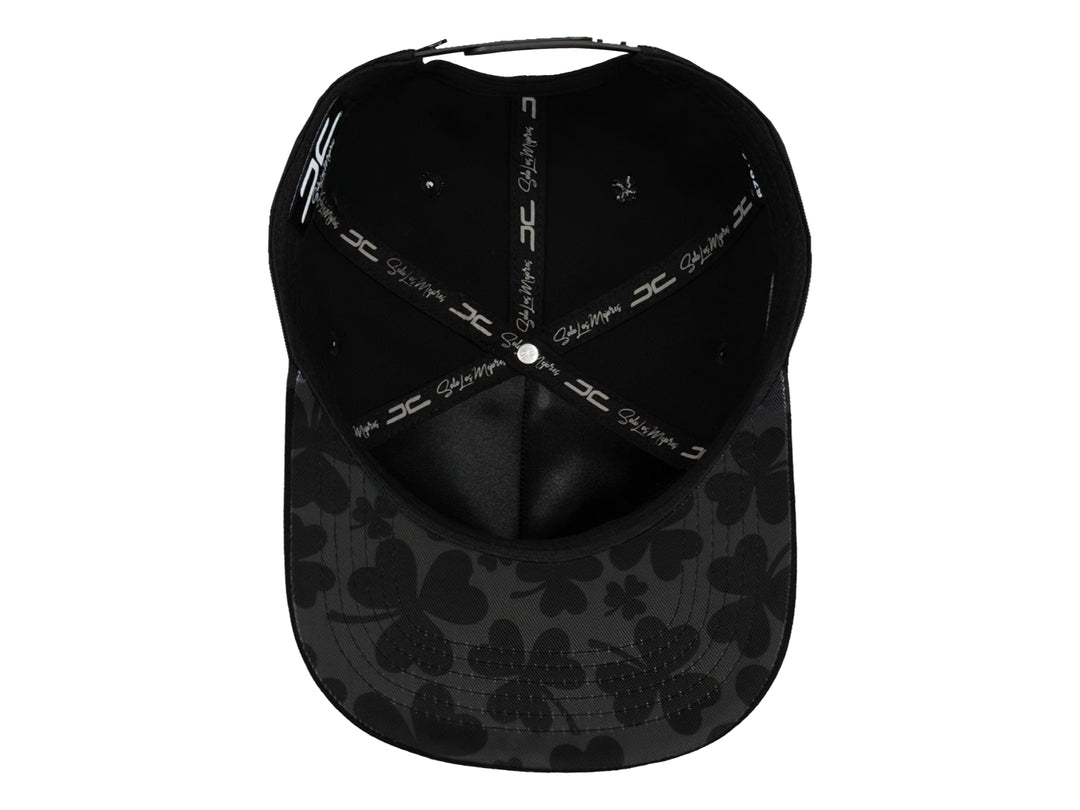 Gorra snapback color negro con un logo de trébol brillante en el frente.