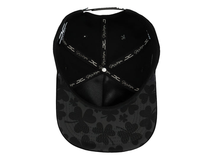 Gorra snapback color negro con un logo de trébol brillante en el frente.