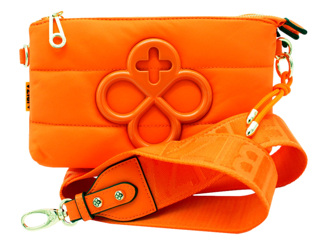 Bolso pequeño color naranja con correa y un elemento decorativo circular en relieve en el frente.