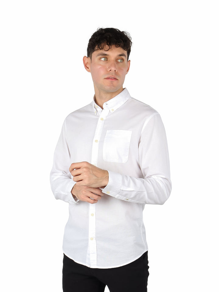 Hombre vistiendo una camisa Oxford de color blanco con manga larga y un bolsillo en el pecho.