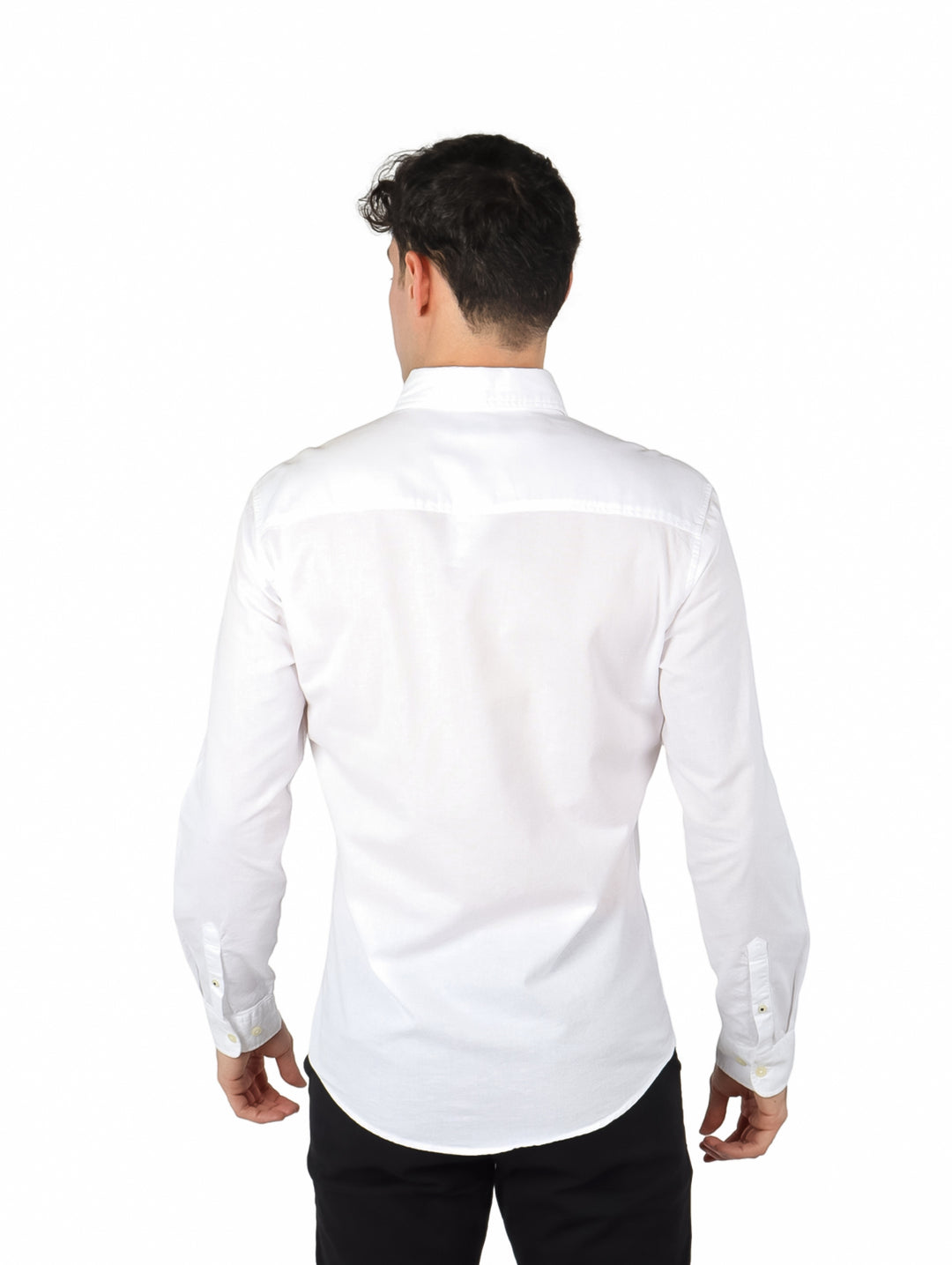 Hombre vistiendo una camisa Oxford de color blanco con manga larga y un bolsillo en el pecho.