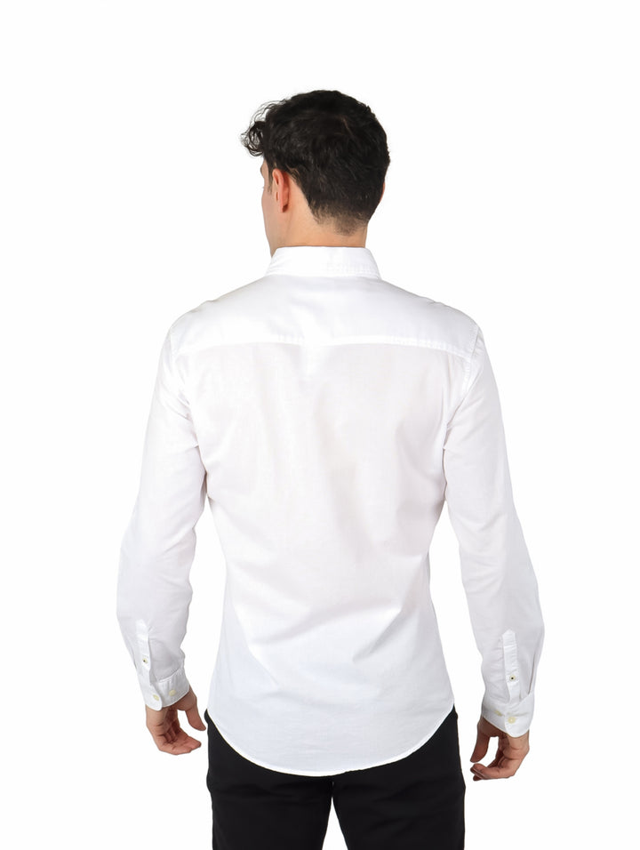 Hombre vistiendo una camisa Oxford de color blanco con manga larga y un bolsillo en el pecho.
