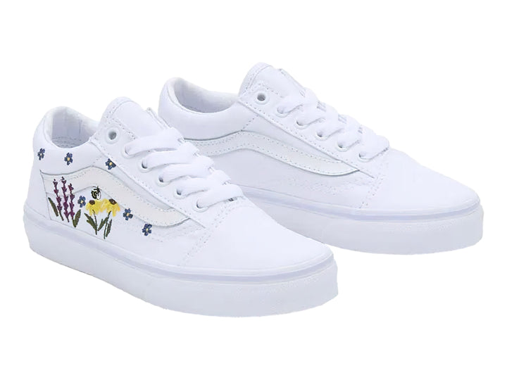 Tenis Vans blancos con bordados de flores coloridas en los laterales.