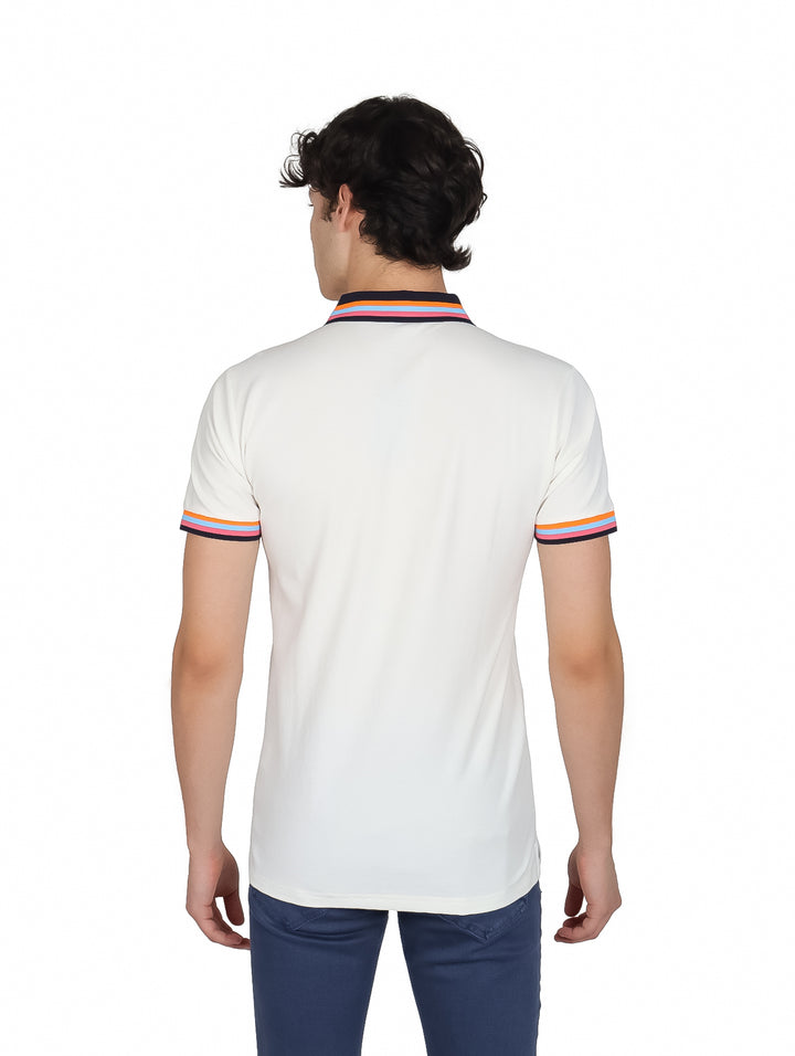 Hombre vistiendo playera polo blanca de manga corta con detalles de rayas coloridas en el cuello y mangas.