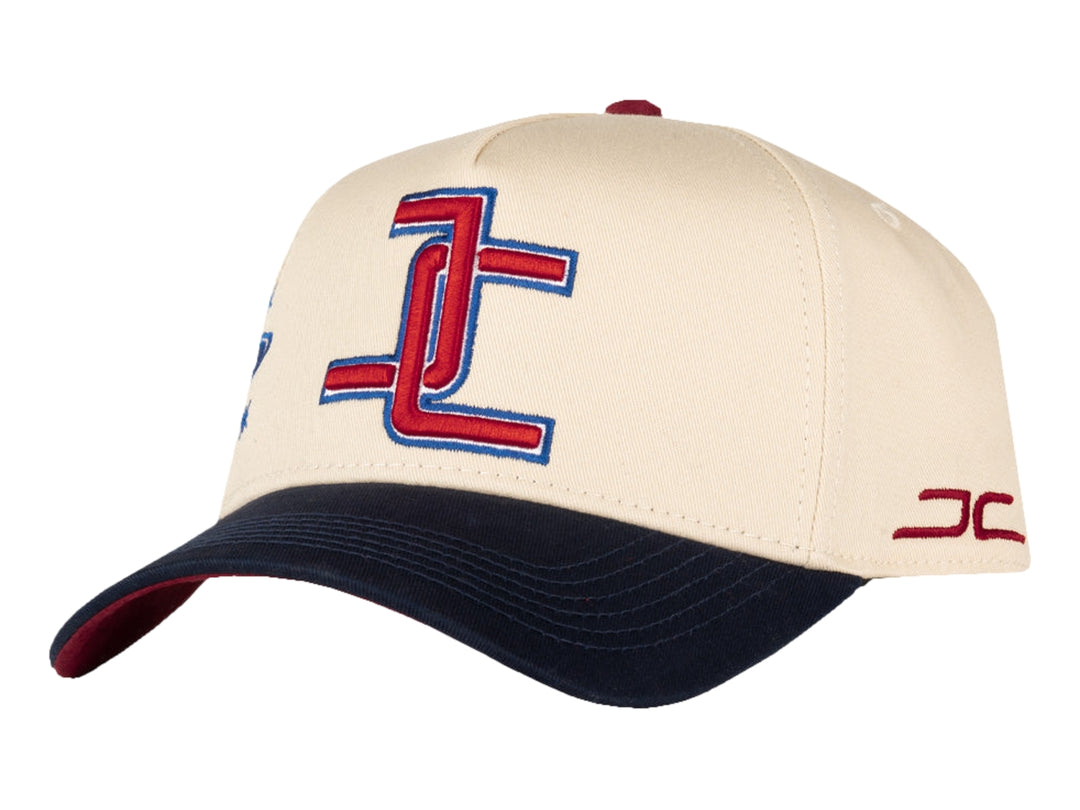 Gorra de béisbol JC HATS en color beige con visera azul marino y logotipo bordado en rojo y azul.