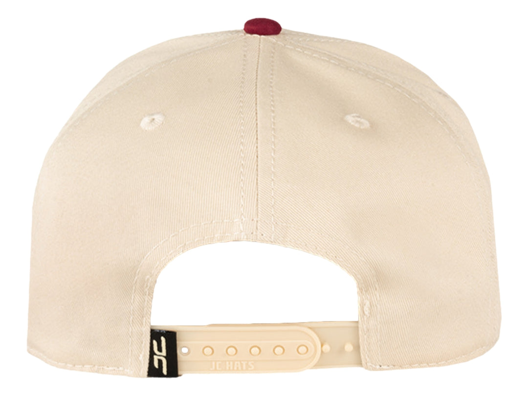 Gorra de béisbol JC HATS en color beige con visera azul marino y logotipo bordado en rojo y azul.