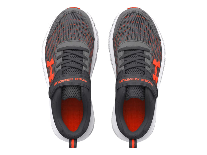 Tenis deportivos Under Armour color gris con detalles en naranja y suela blanca.