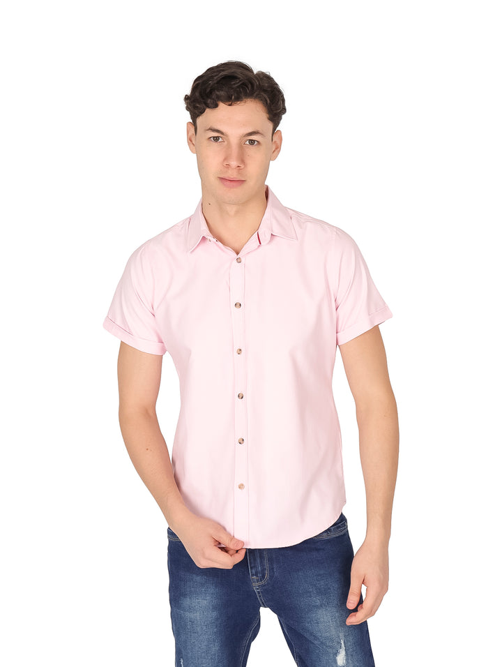 Hombre vistiendo una camisa de color rosa claro con manga corta y botones frontales.