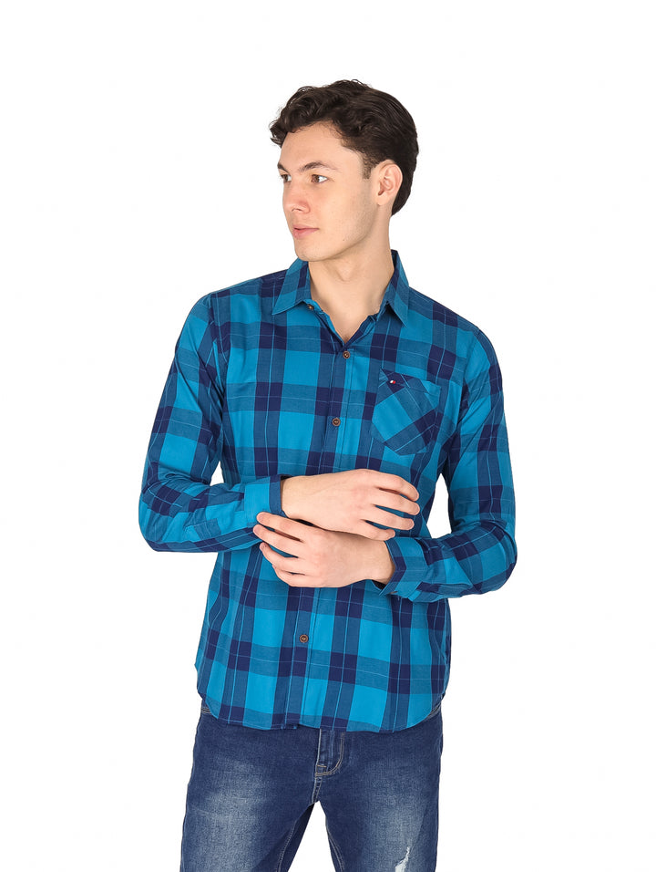 Hombre vistiendo una camisa de manga larga a cuadros en tonos azul y marino.