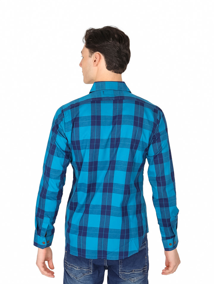 Hombre vistiendo una camisa de manga larga a cuadros en tonos azul y marino.