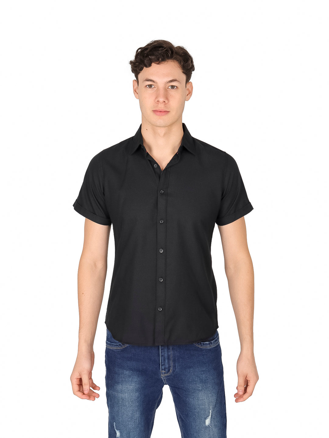 Hombre vistiendo una camisa negra de manga corta con botones y pantalones jeans azules.