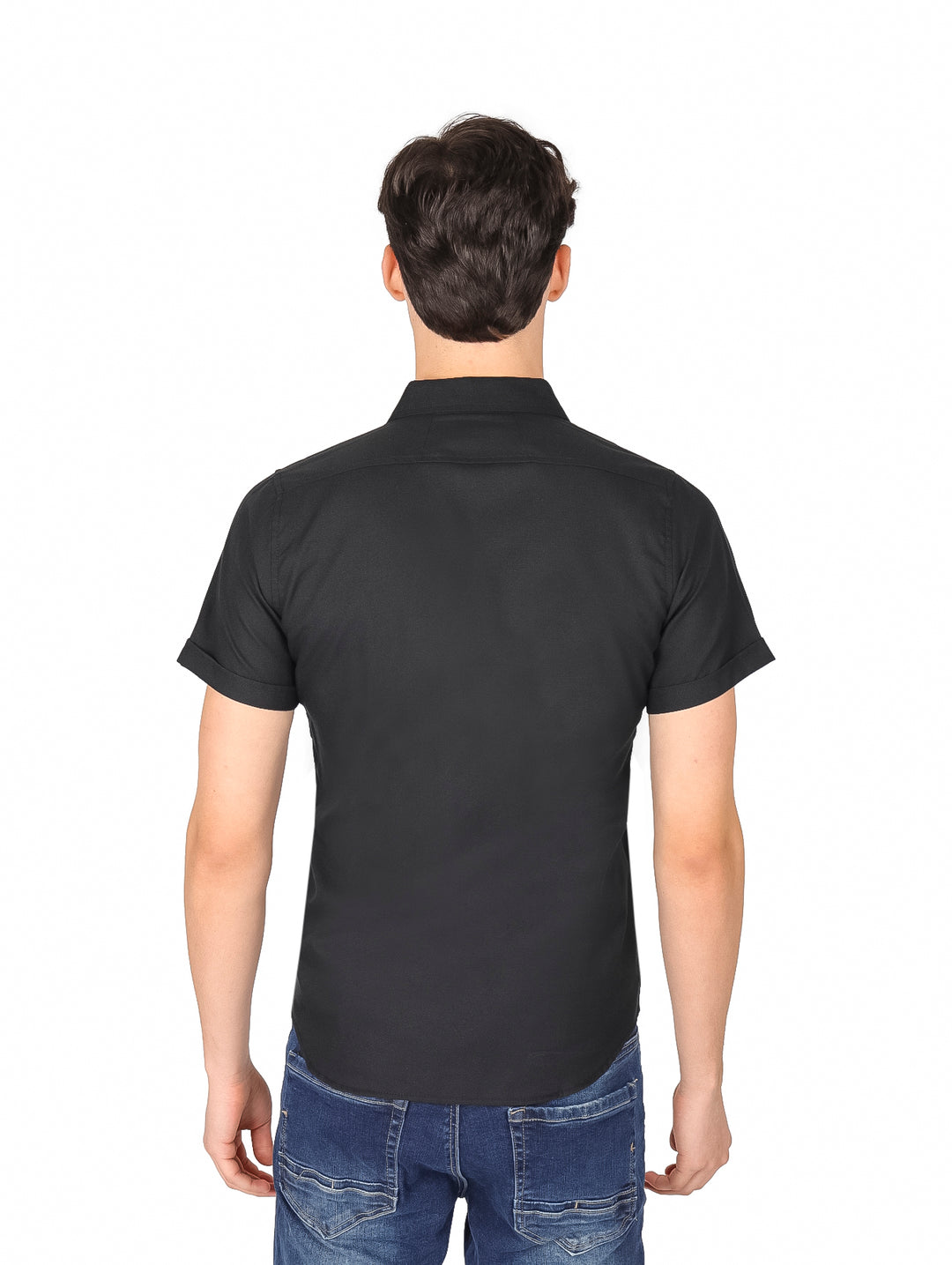 Hombre vistiendo una camisa negra de manga corta con botones y pantalones jeans azules.