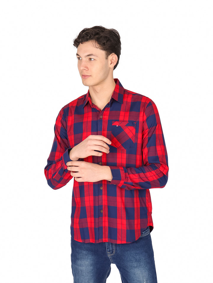 Hombre vistiendo una camisa de cuadros rojos y azul marino de manga larga.