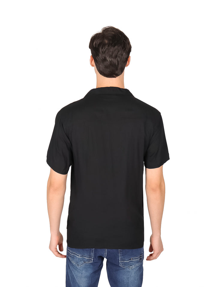Hombre vistiendo una camisa negra de manga corta con botones y cuello, estilo casual.
