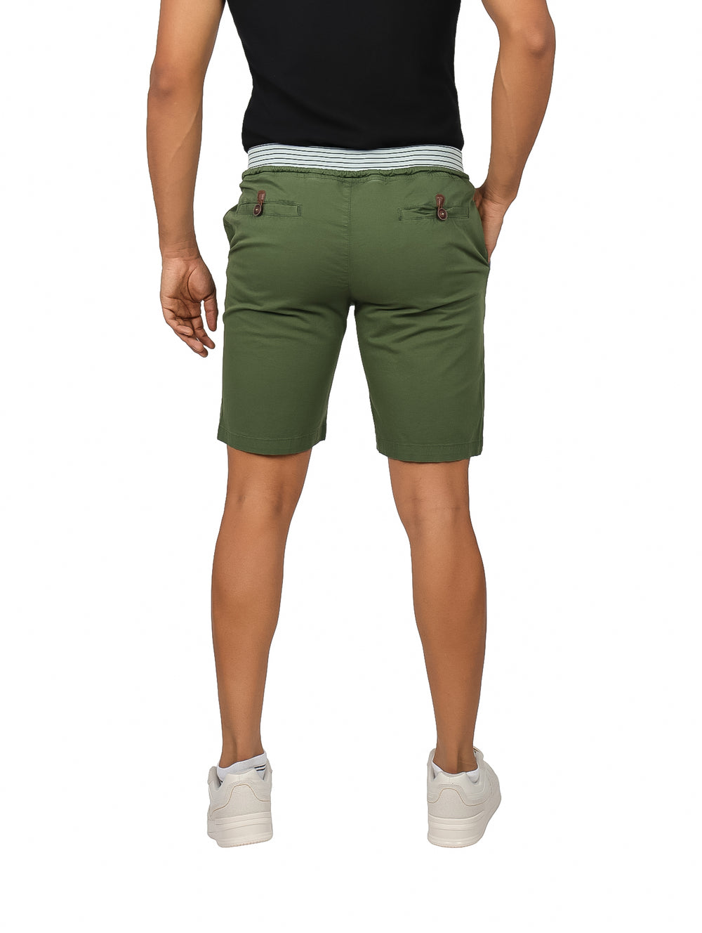 Hombre vistiendo bermudas color olivo con cintura elástica y tenis blancos.