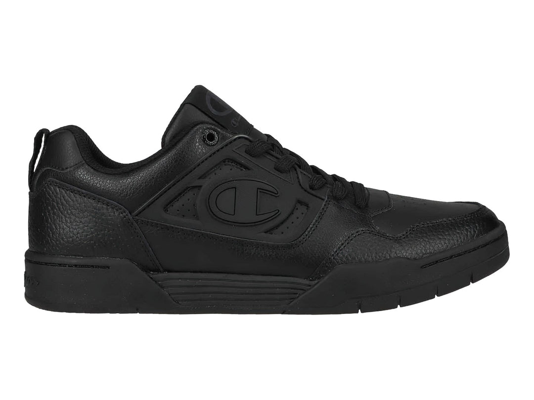 Tenis Champion color negro, corte bajo, con textura de cuero sintético y suela negra.