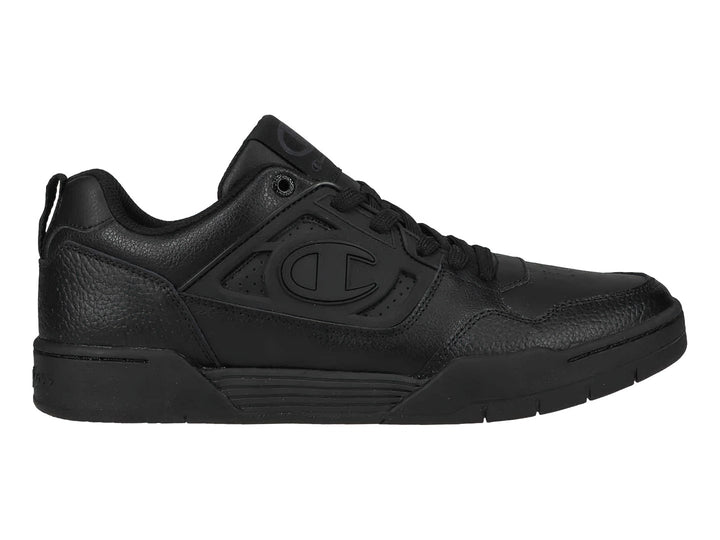 Tenis Champion color negro, corte bajo, con textura de cuero sintético y suela negra.