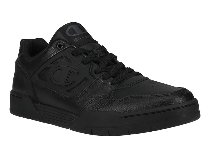 Tenis Champion color negro, corte bajo, con textura de cuero sintético y suela negra.