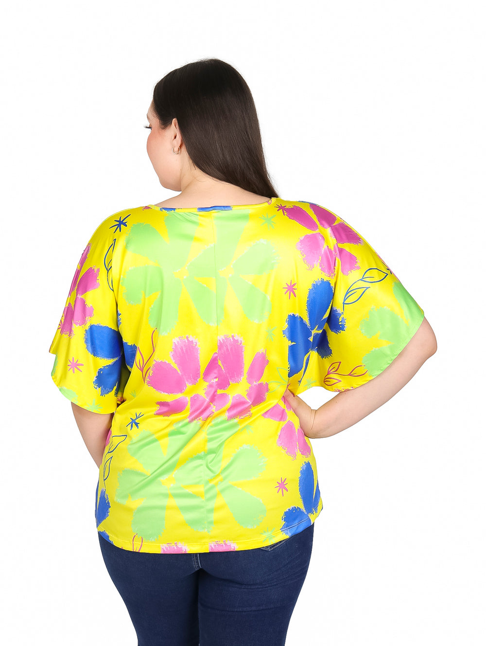 Mujer vistiendo blusa amarilla de manga corta con estampado floral en colores rosa, azul y verde.