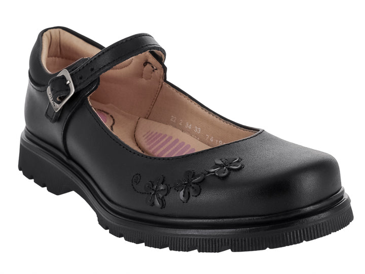 Zapato negro para niña estilo Mary Jane con correa, hebilla metálica y detalles decorativos de flores en la punta.
