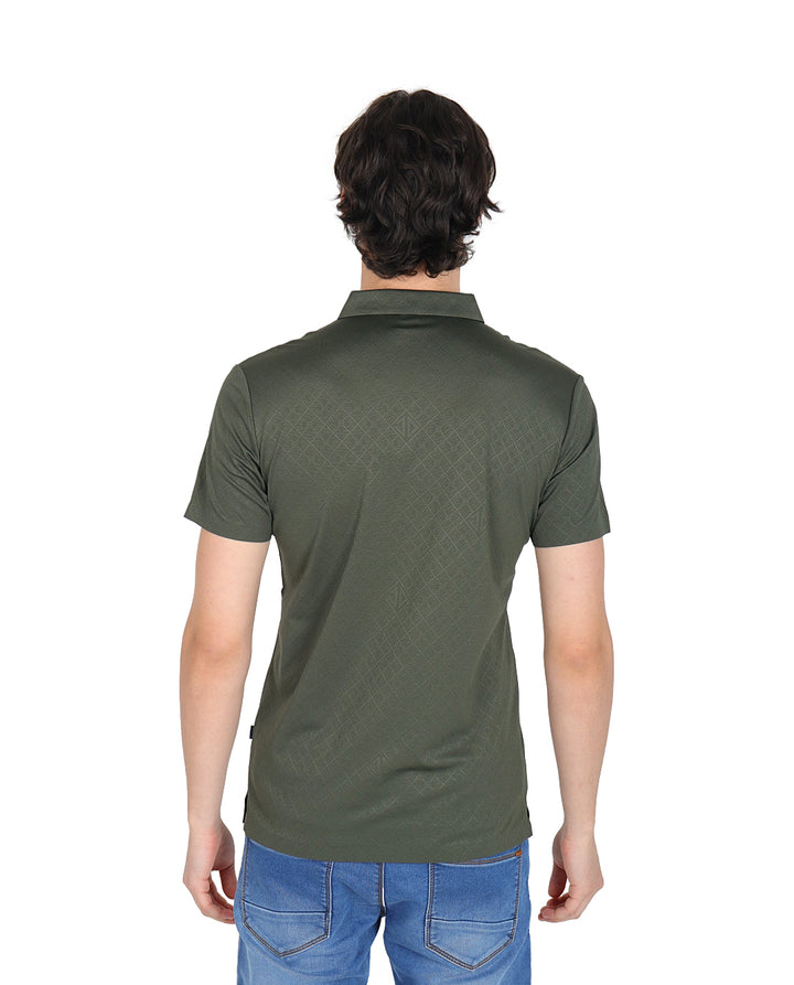 Hombre vistiendo playera polo color olivo con textura geométrica y manga corta.