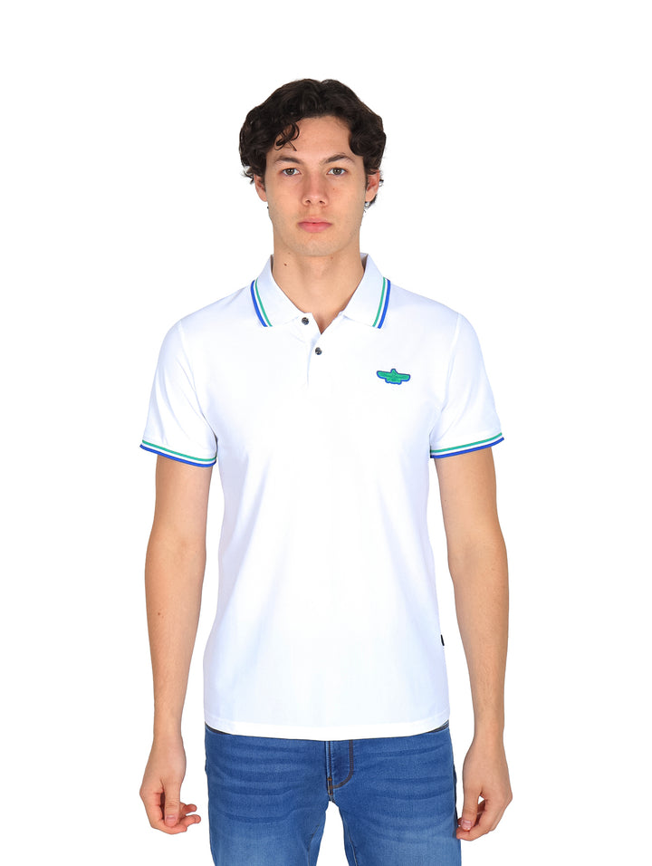 Hombre vistiendo una playera polo blanca con detalles azules y verdes en el cuello y mangas.