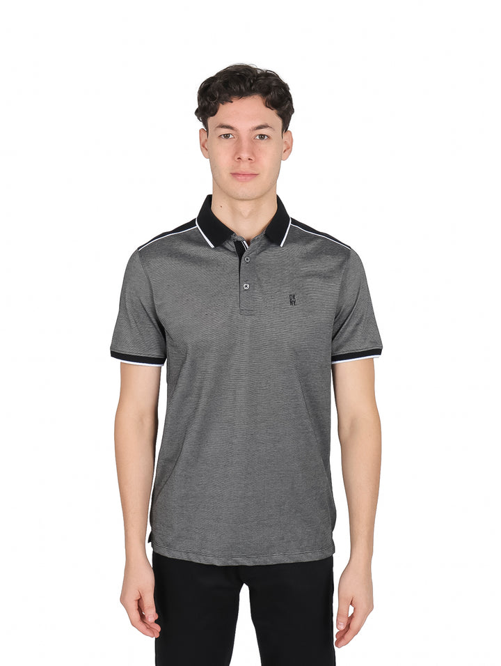 Hombre vistiendo playera polo gris DKNY con detalles negros en cuello y mangas.