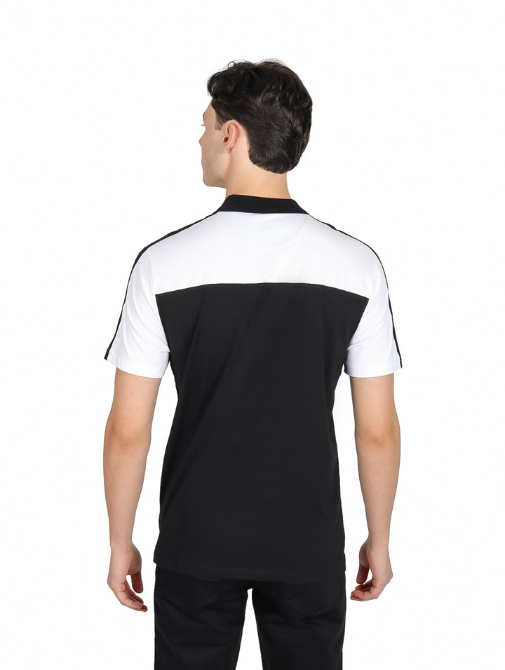 Hombre vistiendo polo DKNY bicolor en blanco y negro con cuello y manga corta.