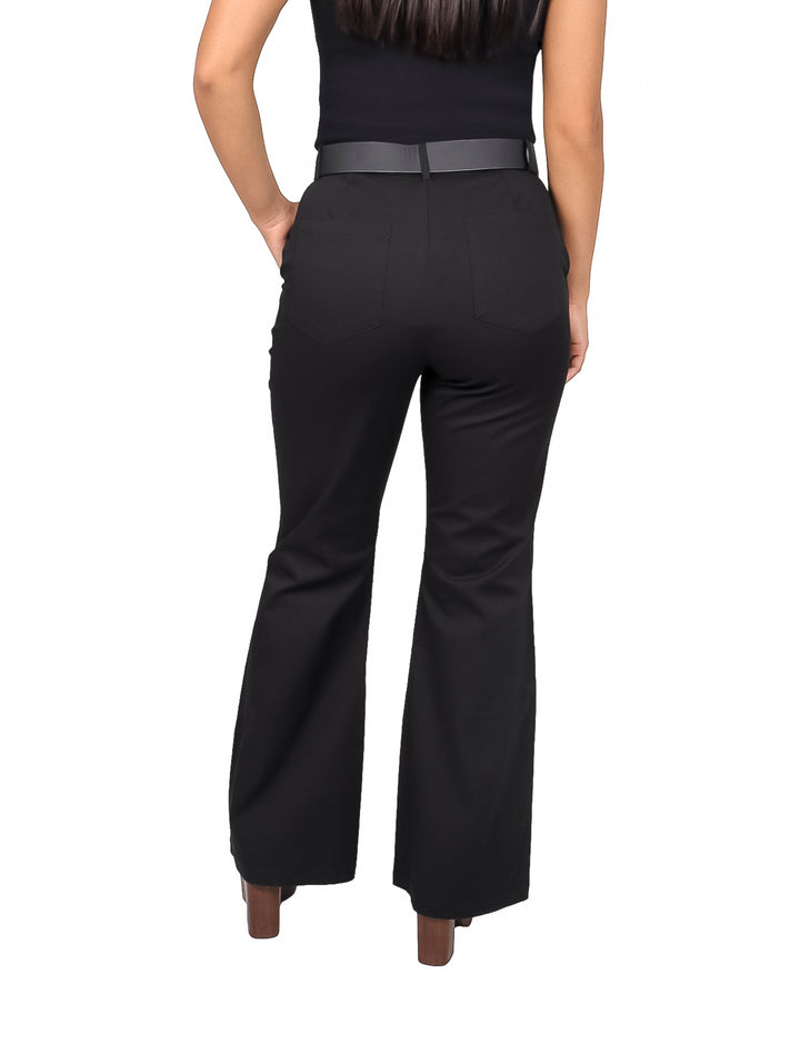 Mujer vistiendo pantalón negro de corte acampanado con cinturón negro y hebilla plateada.
