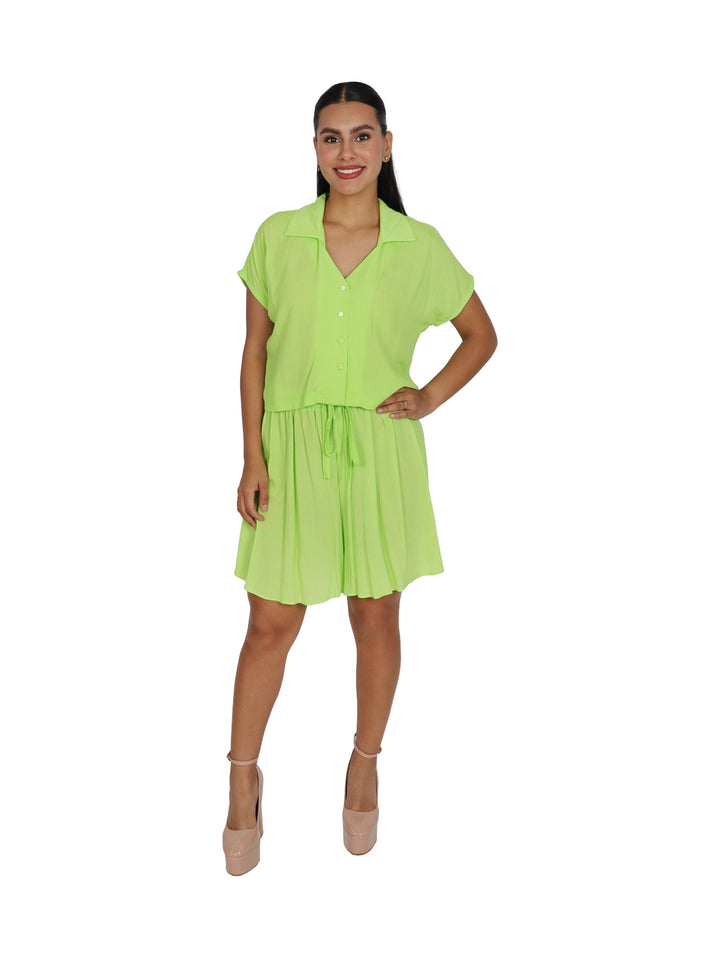 Mujer vistiendo un conjunto de dos piezas en color verde brillante compuesto por camisa y falda corta.