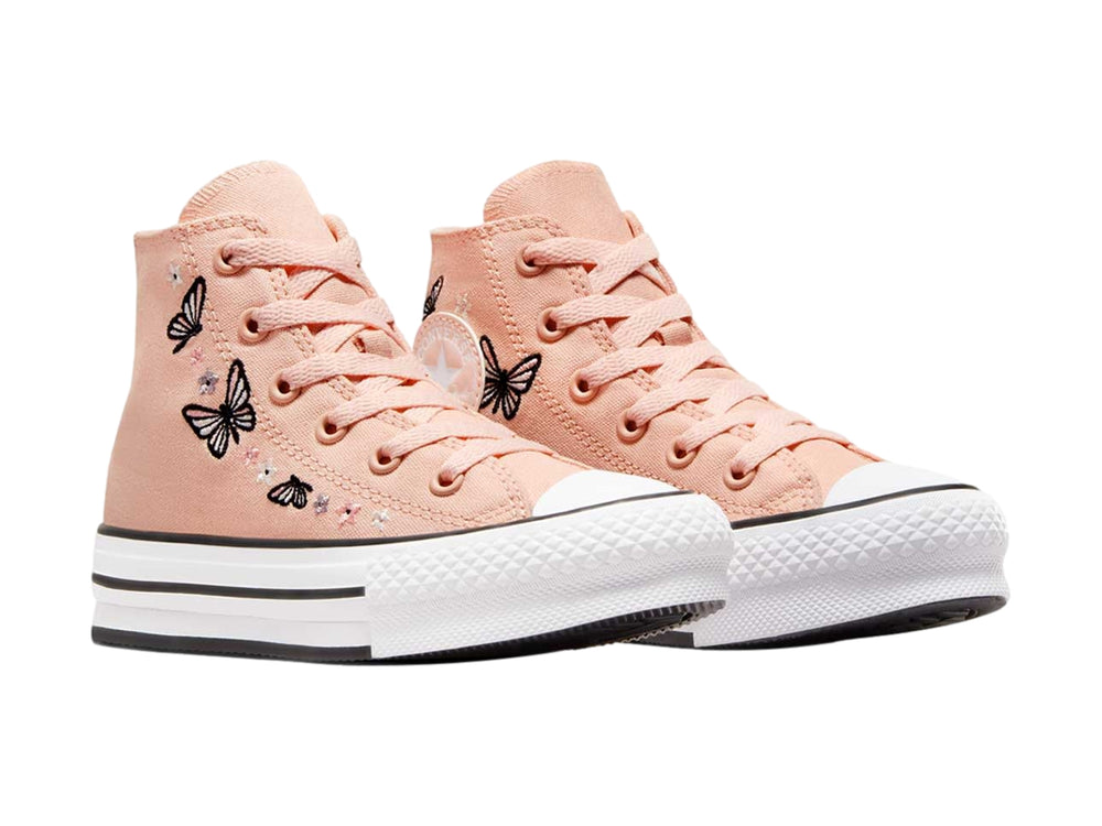 Tenis Converse Chuck Taylor All Star de color durazno con estampado de mariposas negras y suela blanca de plataforma.