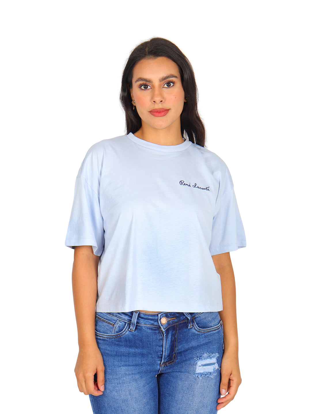 Mujer vistiendo una camiseta Lacoste de color azul claro con corte boxy y cuello redondo.