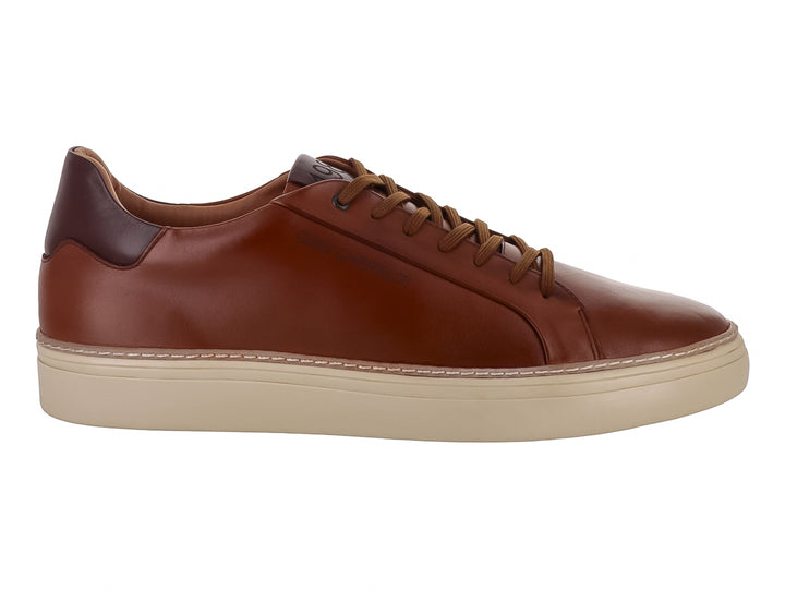 Tenis casuales de cuero color canela con suela color crema y detalle marrón oscuro en el talón.
