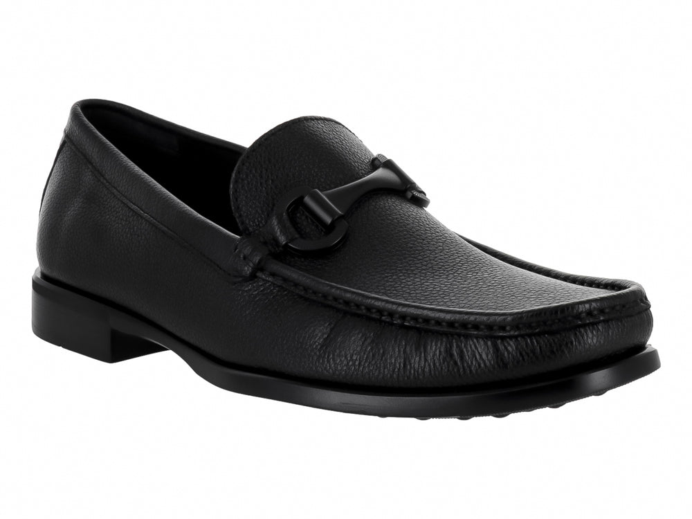 Zapato mocasín de cuero negro para hombre con detalle de hebilla y textura granulada.