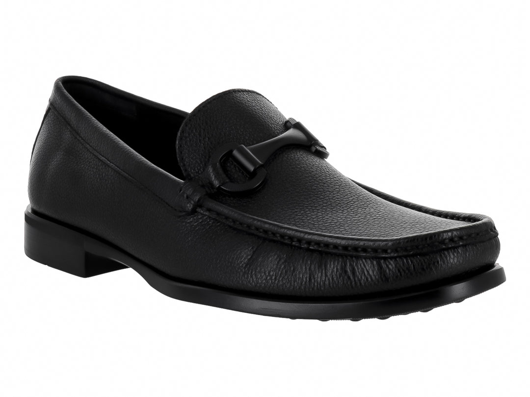 Zapato mocasín de cuero negro para hombre con detalle de hebilla y textura granulada.