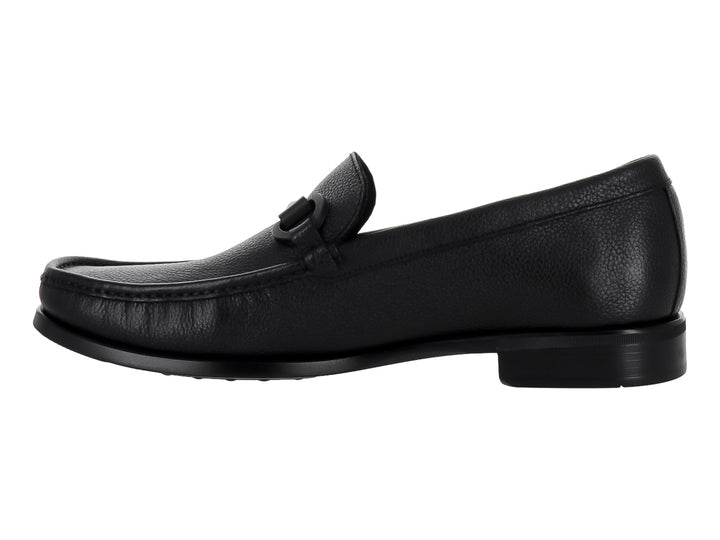 Zapato mocasín de cuero negro para hombre con detalle de hebilla y textura granulada.
