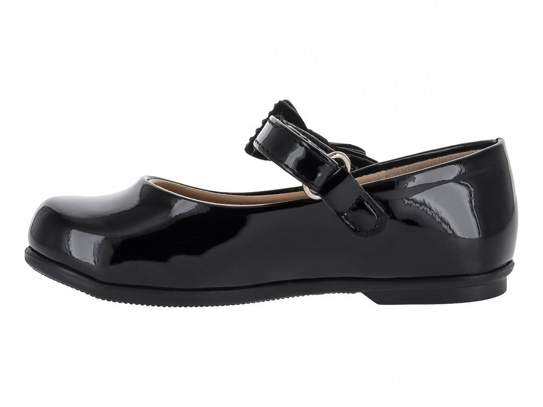 Zapato plano de charol negro con moño decorado y correa.