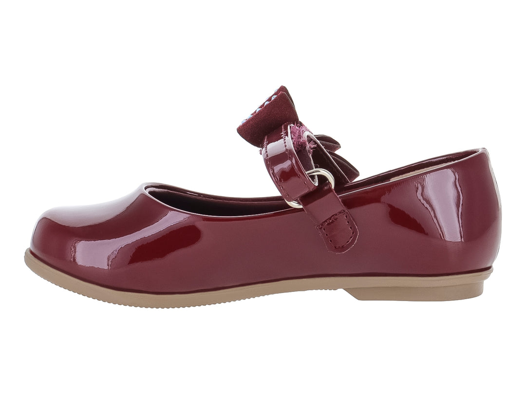 Zapato plano de charol color vino con moño adornado con brillantes y suela beige.