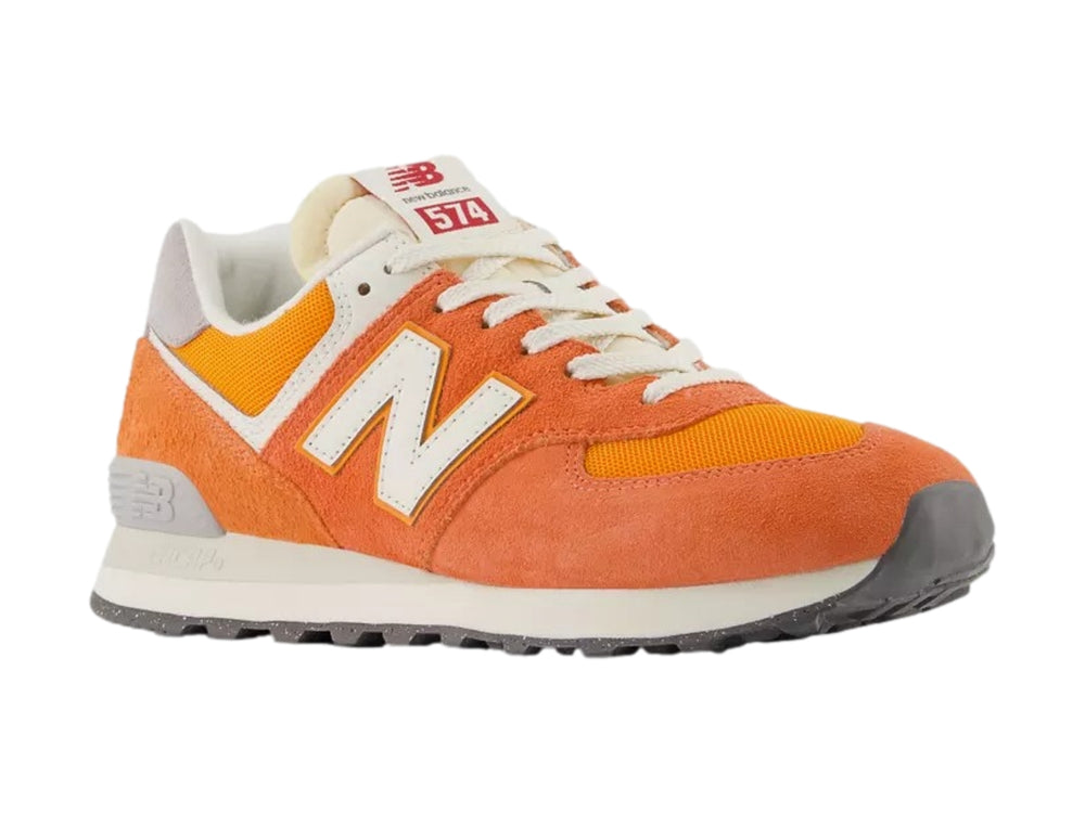 Tenis New Balance modelo 574 en color naranja atómico con detalles en blanco y gris.